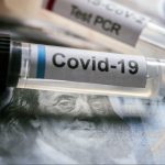 Vial of coronavirus on american banknotes, conceptual image