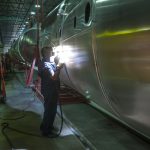 Worker welding large tank in factory